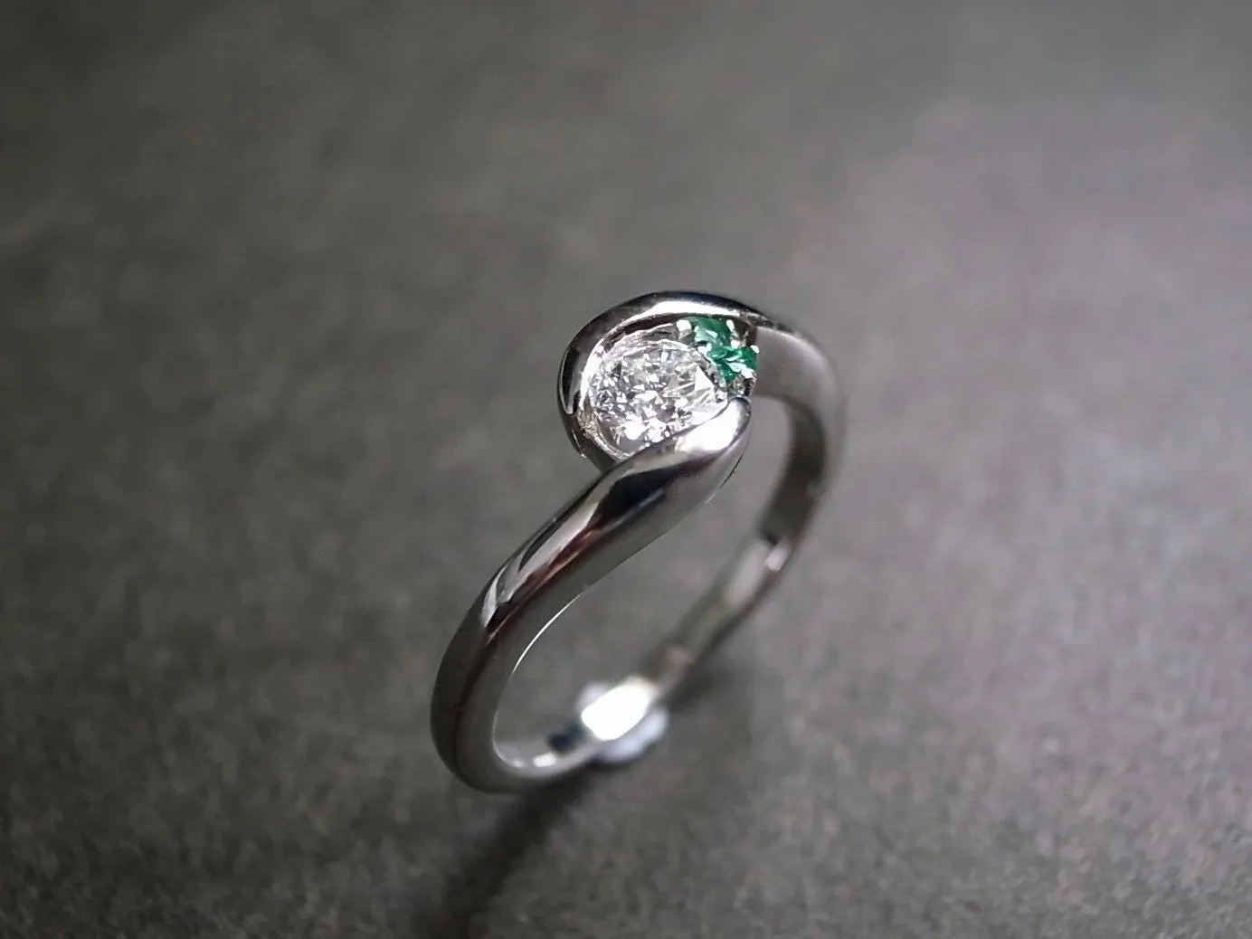 Round Brilliant Cut Diamond and Emerald Twist Ring in White Gold